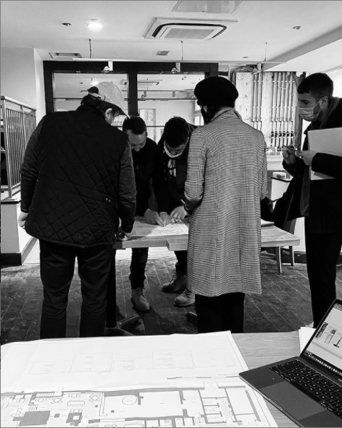 Designers gathered around a table looking at plans for the interior at MELT in Bromsgrove